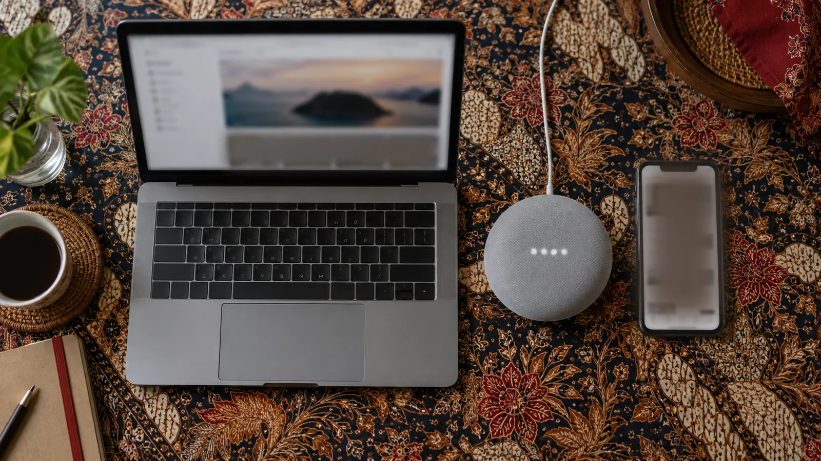 Ilustrasi: Laptop, speaker pintar, dan ponsel berjajar di atas taplak batik untuk membandingkan SEO, AEO, dan GEO.